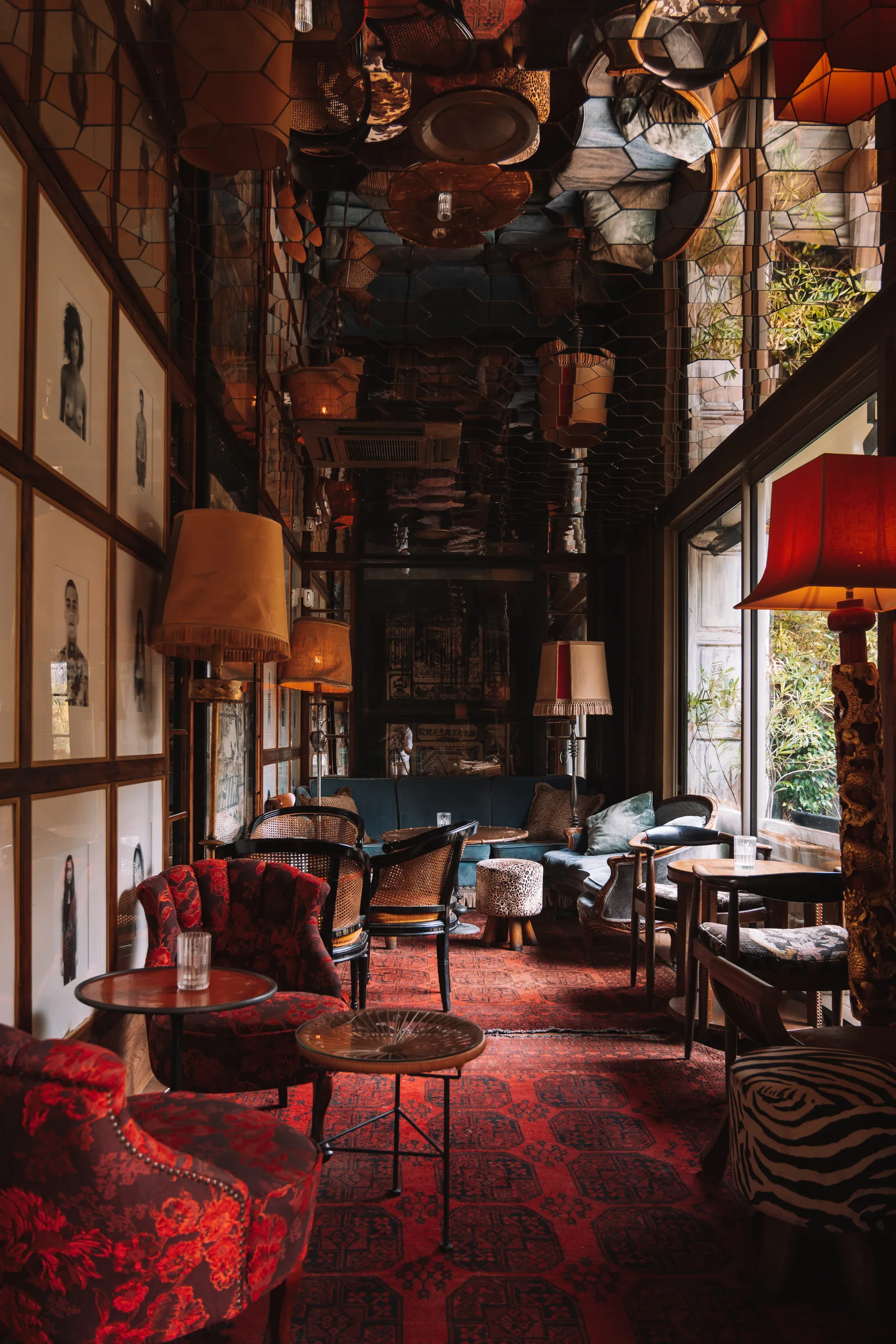 Hexagonal mirrored-ceiling lounge with red floral armchairs